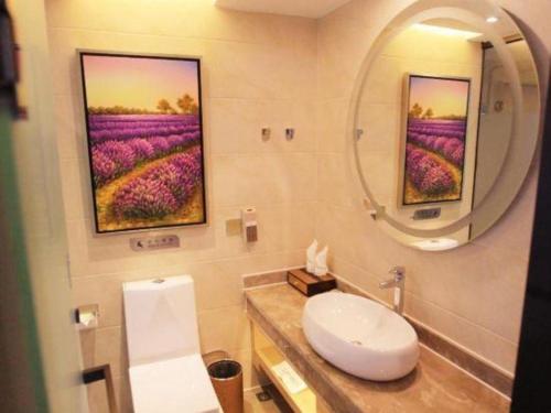 a bathroom with a sink and a mirror and flowers at Lavande Hotel Zhaoqing government Dinghu Mountain Scenic Spot in Zhaoqing