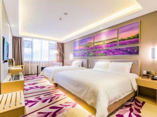 a hotel room with two beds and a painting on the wall at Lavande Hotel Zhaoqing government Dinghu Mountain Scenic Spot in Zhaoqing