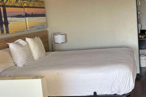 a bedroom with a bed with white sheets and pillows at Days Inn & Suites by Wyndham Byram in Byram