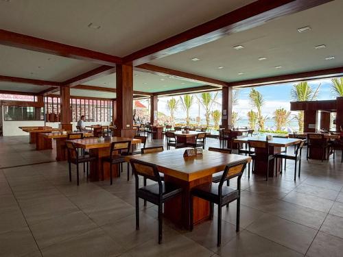 a restaurant with wooden tables and chairs and large windows at The Sky & Sea Koh Larn in Ko Larn
