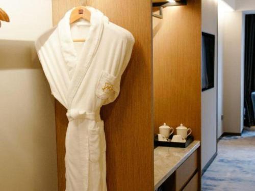a robe hanging on a wall in a hotel room at Grand Metropark Hotel Chongqing in Chongqing