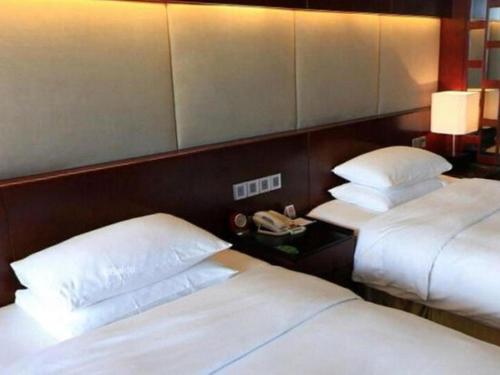 two beds in a hotel room with two bedsskirts at Grand Metropark Hotel Chongqing in Chongqing