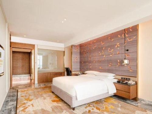 a bedroom with a white bed and a wooden wall at Grand Metropark Hotel Chongqing in Chongqing