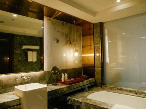 a bathroom with a tub and a sink and a bath tub at Grand Metropark Hotel Chongqing in Chongqing