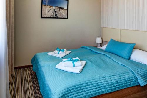 pokój hotelowy z łóżkiem i ręcznikami w obiekcie Marina Jastarnia Apartamenty w budynku z Basenem w Jastarni