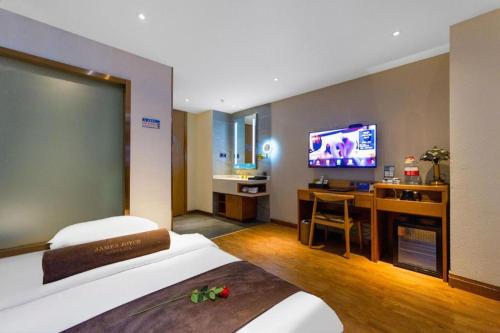 a hotel room with a bed and a flat screen tv at James Joyce Coffetel Xi'an Lingtong The Terracotta Army Huaqingchi University Town Metro Station in Xi'an