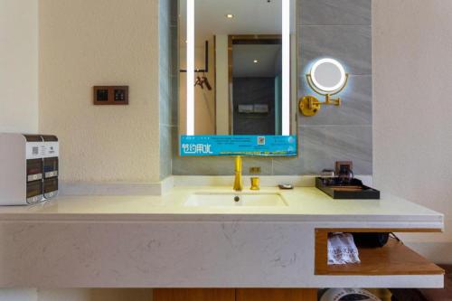 a bathroom with a sink and a mirror at James Joyce Coffetel Xi'an Lingtong The Terracotta Army Huaqingchi University Town Metro Station in Xi'an