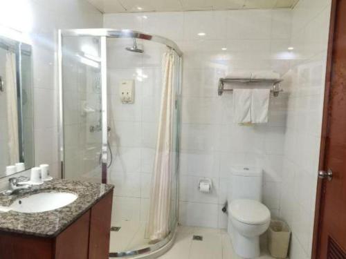 a bathroom with a shower and a toilet and a sink at GreenTree Inn Suzhou Shengze Hotel in Suzhou