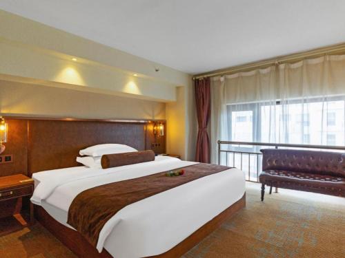 a hotel room with a large bed and a balcony at James Joyce Coffetel Xi'an Lingtong The Terracotta Army Huaqingchi University Town Metro Station in Xi'an