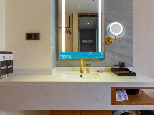 a bathroom counter with a sink and a mirror at James Joyce Coffetel Xi'an Lingtong The Terracotta Army Huaqingchi University Town Metro Station in Xi'an