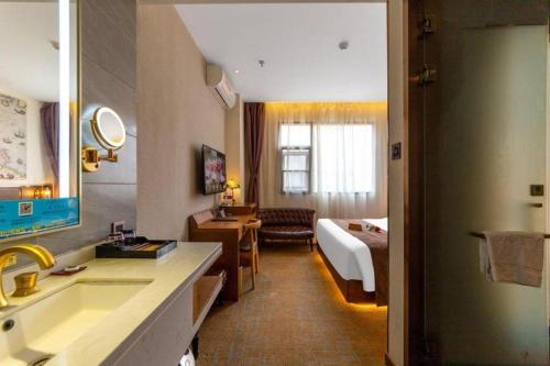 a hotel room with a sink and a bedroom at James Joyce Coffetel Xi'an Lingtong The Terracotta Army Huaqingchi University Town Metro Station in Xi'an