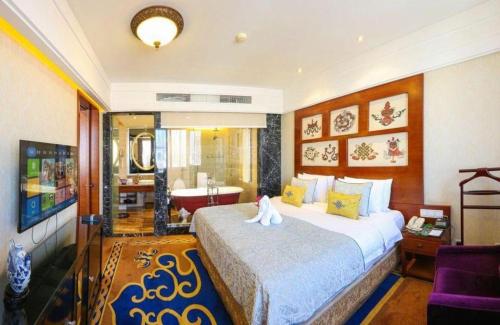 a bedroom with a large bed and a bathroom at Hohhot Inner Mongolia Hotel in Hohhot