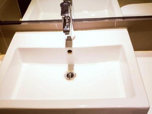 a white sink with a faucet in a bathroom at JTOUR Inn Guilin Two Rivers and Four Lakes Walmart in Guilin
