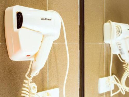 a white phone is hanging on a wall at JTOUR Inn Guilin Two Rivers and Four Lakes Walmart in Guilin
