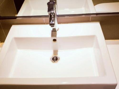 a white sink with a faucet in a bathroom at JTOUR Inn Guilin Two Rivers and Four Lakes Walmart in Guilin