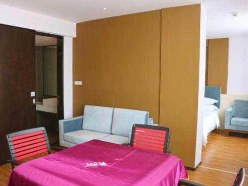 a room with a table and two chairs and a bed at JTOUR Inn Guilin Two Rivers and Four Lakes Walmart in Guilin