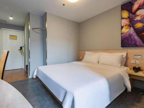 a bedroom with a large white bed in a room at 7 Days Inn Nanchang Bayi Square Zhongshan Road Wanshou Palace in Nanchang