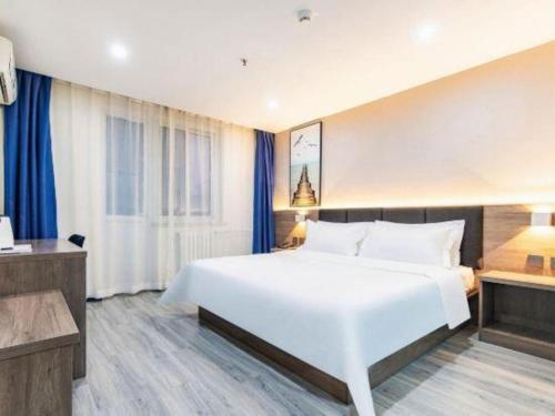 a large white bed in a hotel room at 7 Days Inn Tianjin Development Zone 3rd Street Wanli in Binhai