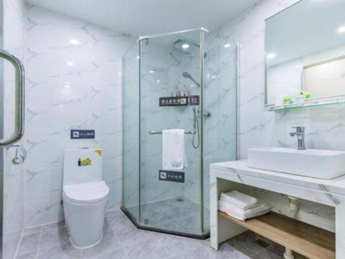 a bathroom with a shower and a toilet and a sink at 7 Days Inn Tianjin Development Zone 3rd Street Wanli in Binhai