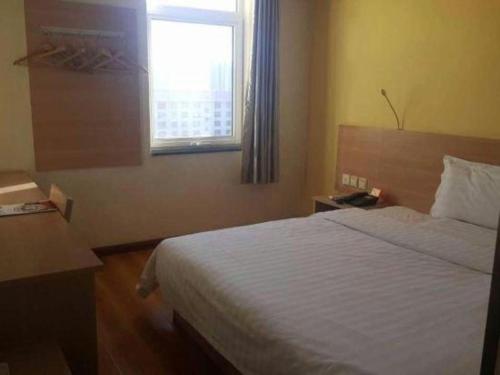 a hotel room with a bed and a window at 7 Days Inn Hohhot University East Street in Hohhot