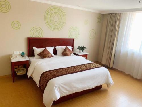 ein Schlafzimmer mit großem Bett und Fenster in der Unterkunft GreenTree Inn Tianjin Dasi Meijiang Huizhanzhongxin Business Hotel in Tianjin