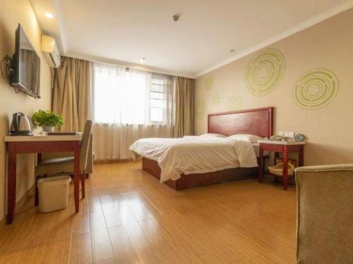 a bedroom with a bed and a desk and a window at GreenTree Inn Tianjin Dasi Meijiang Huizhanzhongxin Business Hotel in Tianjin