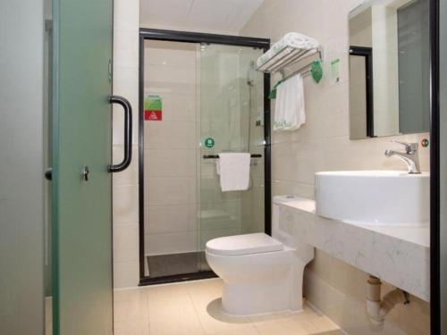 a bathroom with a shower and a toilet and a sink at Vatica Shanghai Jiading District Anting Metro Station Moyu Road Hotel in Shanghai