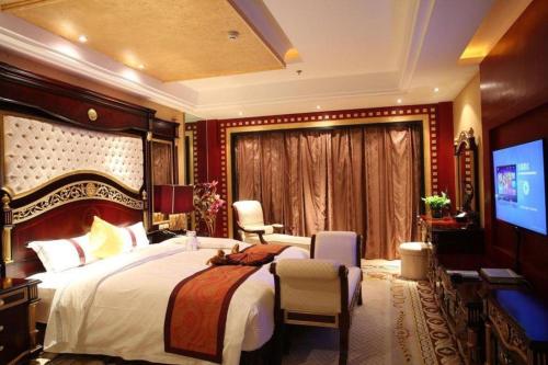 a bedroom with a large bed and a television at Dunhuang Grand Soluxe Hotel in Dunhuang