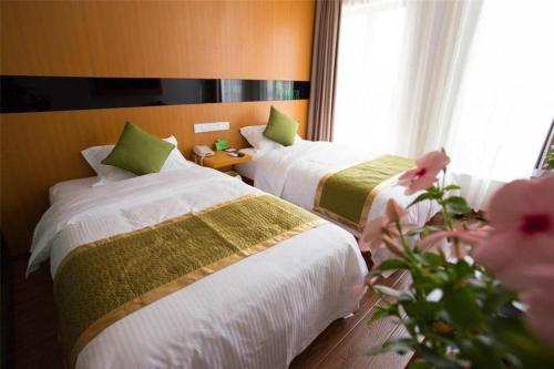 a hotel room with two beds and a window at Vatica Shanghai Jiading District Anting Metro Station Moyu Road Hotel in Shanghai