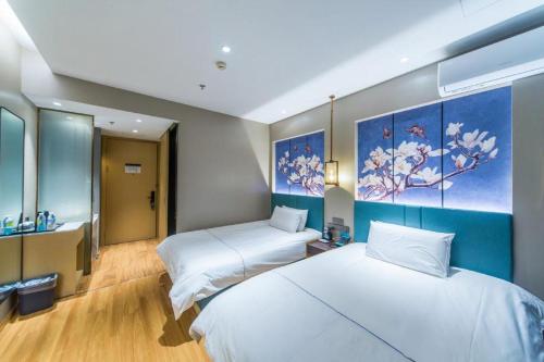 Una habitación con dos camas y un cuadro en la pared. en Jinjiang Inn Jinan Shimao Kuanhouli Quancheng Road, en Jinan