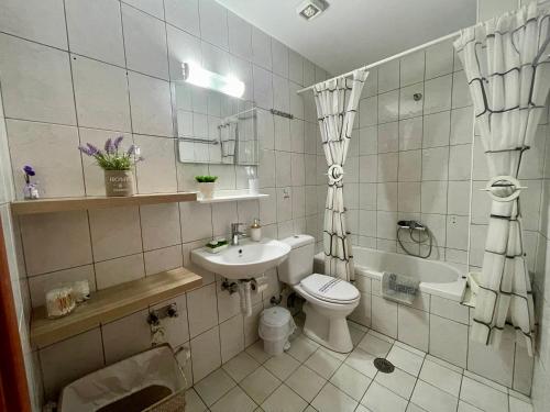łazienka z toaletą, umywalką i wanną w obiekcie Heaven Studios & Apartments w mieście Stalida