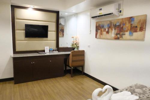 a room with a desk and a tv on a wall at Islands Hotel in Roxas City