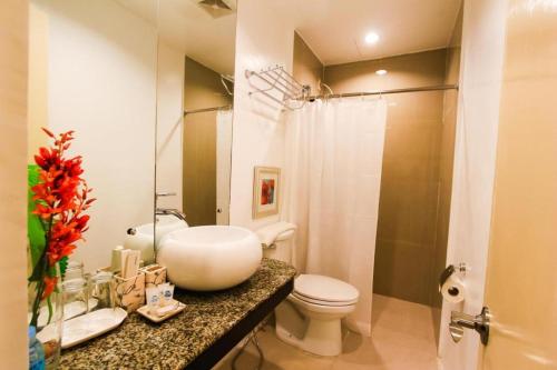 a bathroom with a sink and a toilet and a shower at Islands Hotel in Roxas City