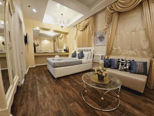 a bedroom with a bed and a couch and a table at Islands Hotel in Roxas City