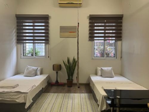 two beds in a room with two windows at April twelve in Hanoi