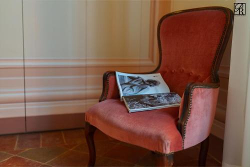 a red chair with a book on it at Palazzo Rossi, Historic Boutique Home in Marche in Sarnano