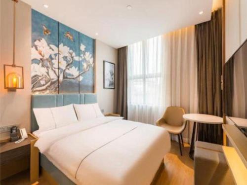 a hotel room with a large bed and a window at Jinjiang Inn Zibo People's Park Liuquan Road in Zibo