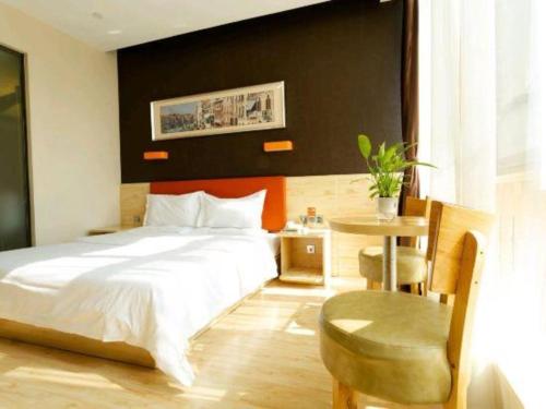 a bedroom with a bed and a table and a chair at 7 Days Premium Qingdao Keji Street Taishan Road Metro Station in Qingdao