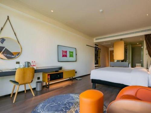 a bedroom with a large bed and a desk at ibis xian North Second Ring Weiyang Rd Hotel in Xi'an