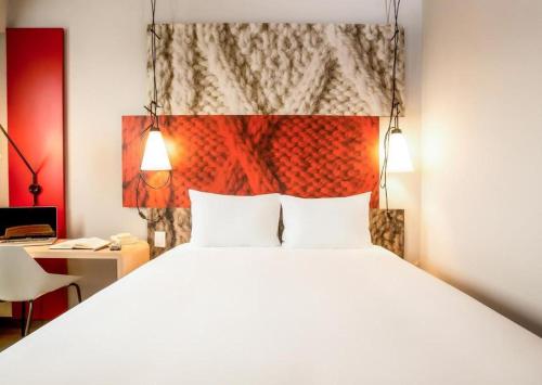a bedroom with a large white bed and a desk at ibis xian North Second Ring Weiyang Rd Hotel in Xi'an