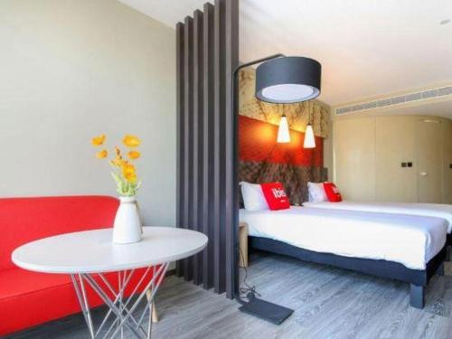 a room with two beds and a table and a table at ibis xian North Second Ring Weiyang Rd Hotel in Xi'an
