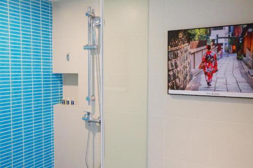 a bathroom with a shower with a tv on the wall at Ibis Styles Shanghai Qingpu Sports Center Hotel in Shanghai