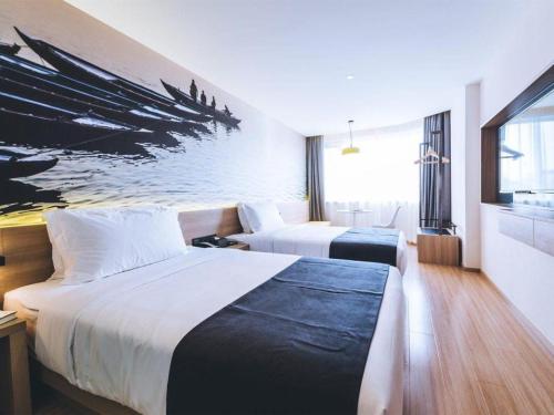 a hotel room with two beds and a painting of a boat at Ibis Styles Shanghai Qingpu Sports Center Hotel in Shanghai
