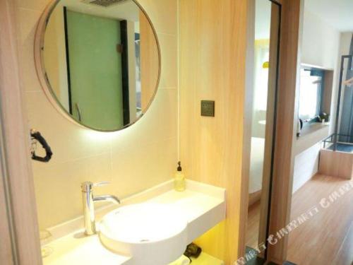 a bathroom with a sink and a mirror at Ibis Styles Shanghai Qingpu Sports Center Hotel in Shanghai