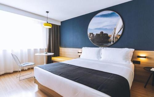a bedroom with a large bed and a round mirror at Ibis Styles Shanghai Qingpu Sports Center Hotel in Shanghai
