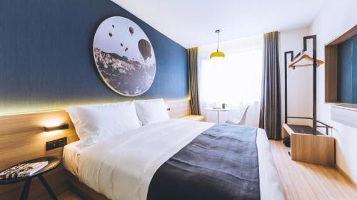 a bedroom with a large bed with a blue wall at Ibis Styles Shanghai Qingpu Sports Center Hotel in Shanghai