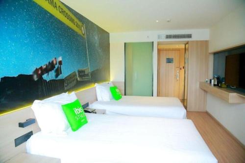 a hotel room with two beds and a tv at Ibis Styles Shanghai Qingpu Sports Center Hotel in Shanghai