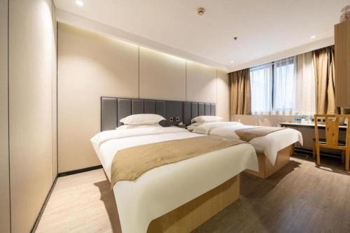 a row of four beds in a bedroom with a desk at GreenTree Inn Shanghai Railway Station Macao Road in Shanghai
