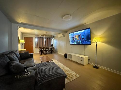a living room with a couch and a flat screen tv at Mango Hostel - 420 Friendly in Bangkok
