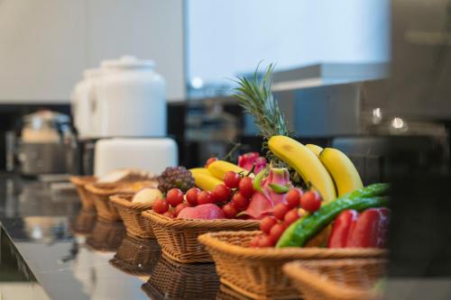 a bunch of baskets of fruits and vegetables on a counter at Yuexuan Hotel Chongqing Jiefangbei Hongyadong Branch in Chongqing
